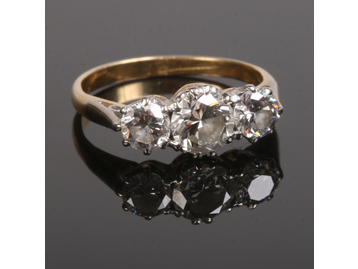 A gold three stone diamond ring set with