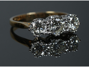 An 18ct gold three stone diamond ring. A