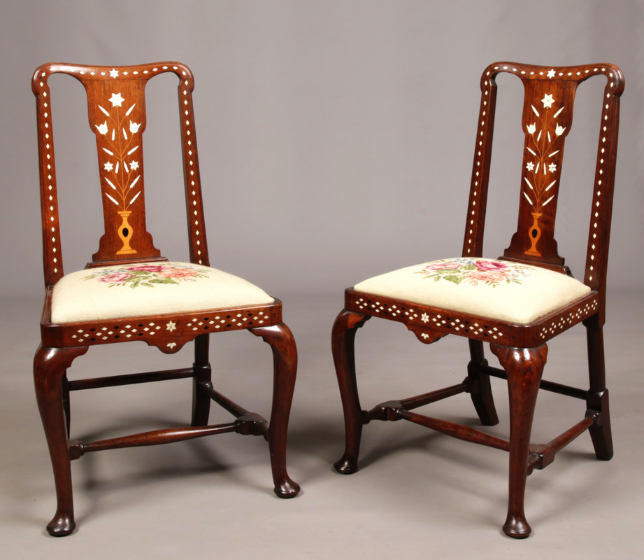 A pair of George I walnut hall chairs of